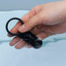 Hand holding a black silicone vibrating ring partially submerged in water, highlighting its waterproof design.