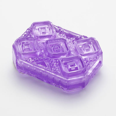 Close-up of the Tenga Uni Amethyst in translucent purple with geometric textured design on a white background.
