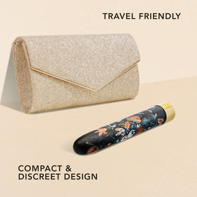 Compact floral-patterned vibrator with gold accent next to a glittery gold clutch, highlighting travel-friendly discreet design.