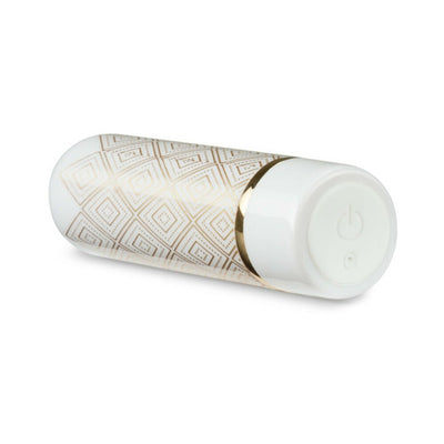 Compact white and gold bullet vibrator with geometric pattern and power button on the base.