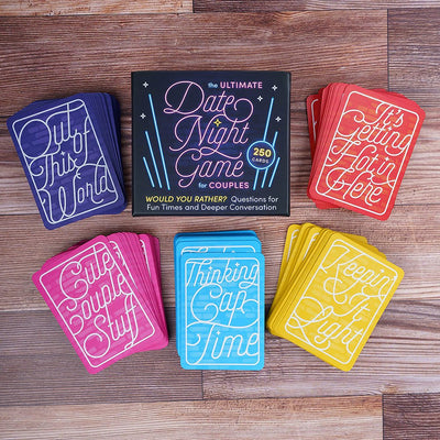 The Ultimate Date Night Game for Couples with five colorful card stacks labeled by category on a wooden surface.