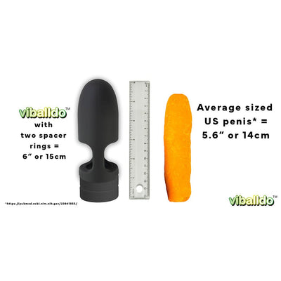 Black Viballdo device with two spacer rings next to a clear ruler and an orange model representing average US penis size for scale.