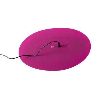 Purple oval-shaped VibePad with a charging cable connected, designed for ergonomic external stimulation.