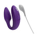 Purple We-Vibe Sync couples vibrator with textured silicone and white USB charging cable on white background.