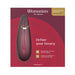 Womanizer Premium 2 clitoral stimulator in burgundy with gold accents on red packaging box.