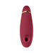 Womanizer Premium 2 clitoral stimulator in deep red with gold accent and silicone suction head, sleek ergonomic design.