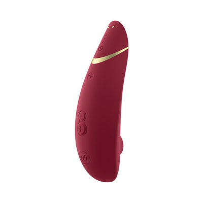 Womanizer Premium 2 clitoral stimulator in deep red with gold accent, featuring ergonomic design and control buttons.