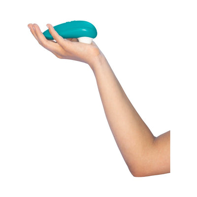 Hand holding a turquoise Womanizer Starlet 3 clitoral stimulator against a white background.