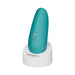 Turquoise Womanizer Starlet 3 clitoral stimulator on white charging stand with control buttons visible