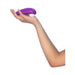 Hand holding a purple Womanizer Starlet 3 clitoral stimulator with white silicone head against a white background.