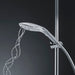 Sleek chrome shower head with water streams flowing, mounted on adjustable vertical rail against dark background.