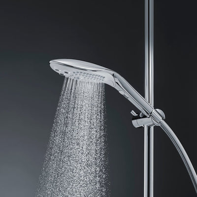 Sleek chrome Womanizer Wave shower head releasing a fine spray of water, mounted on adjustable shower rail with hose.
