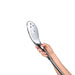 Hand holding the sleek chrome Womanizer Wave shower head with multiple water jet nozzles and ergonomic button control.