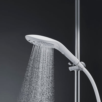 White Womanizer Wave shower head with water flowing, mounted on chrome shower rail against dark background.