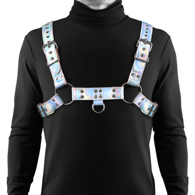 Man wearing a rainbow-colored adjustable chest harness with silver hardware over a black turtleneck shirt