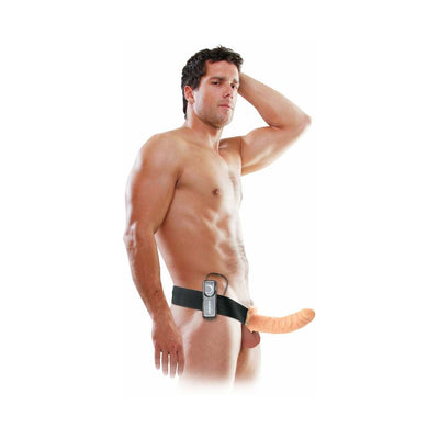 Man wearing an adjustable black harness with an 8-inch flesh-colored hollow strap-on and attached remote control.