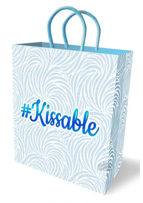 Pastel blue and white gift bag with swirling pattern and #Kissable logo, featuring sturdy woven handles.