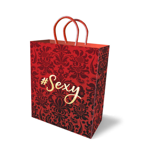 Red gift bag with black floral damask pattern and gold foil #Sexy text, featuring red rope handles.