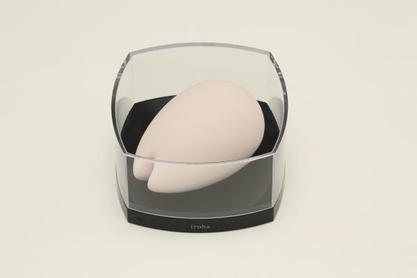 Pink Tenga Iroha Sakura massager with smooth curves displayed in a clear protective charging case.