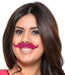 Woman wearing a bright pink adhesive party mustache from a 6-count mustache party favor kit.