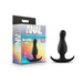 Black curved silicone anal plug with ergonomic base next to its colorful packaging box.