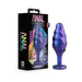 Purple and blue swirled textured anal plug with heart-shaped base and jewel, next to its black Anal Adventures packaging.