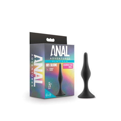 Small black silicone beginner anal plug with tapered tip and flared base next to its colorful Anal Adventures Platinum packaging.
