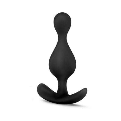 Black silicone anal plug with a curved base and a tapered, wave-shaped body for comfortable wear and enhanced sensation.