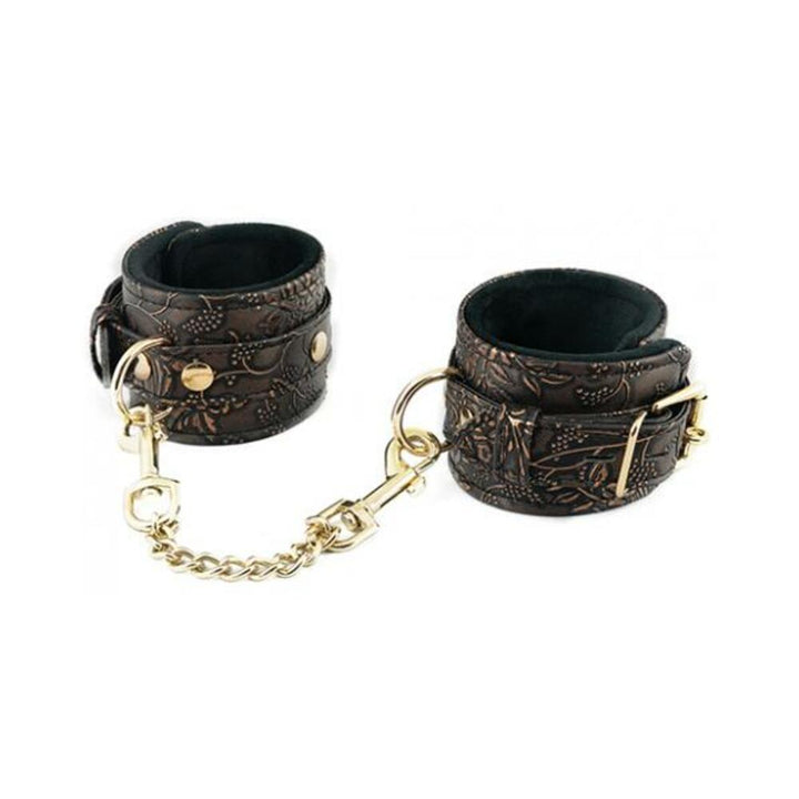 Brown floral embossed PU ankle restraints with black faux fur lining and gold chain connectors on white background.