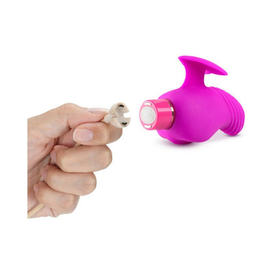 Hand holding magnetic USB charging cable next to a plum-colored finger vibrator with ribbed head and heart-shaped finger fin.