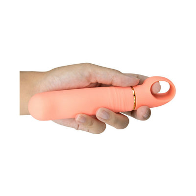 Hand holding a coral-colored curved vibrator with an easy-grip loop handle and smooth silicone finish.