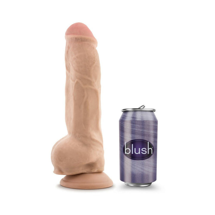 Realistic vanilla-colored dildo with suction base next to a purple Blush brand soda can for size comparison.