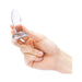 Hand holding a small clear glass anal dilator with a smooth tapered shape and flared base.