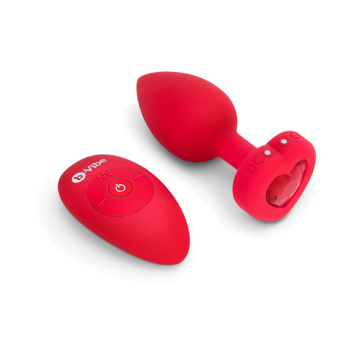 Red heart-shaped vibrating jewel plug with matching remote control on white background