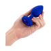Hand holding a blue silicone vibrating jewel plug with a faceted sapphire-colored base jewel.