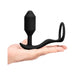 Hand holding the black b-Vibe Vibrating Snug & Tug Medium, a silicone hybrid ring and weighted plug.