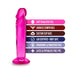 Pink translucent dildo with suction cup base and text highlighting soft feel, harness compatible, body safe, and phthalate-free features.
