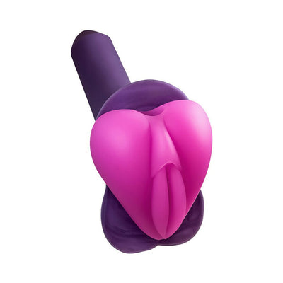 Hot pink silicone Lippi stimulator with plump lips and slit, shown on a purple base for use with strap-on harnesses.
