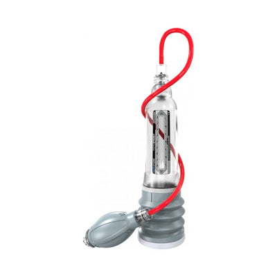 Clear Bathmate Hydroxtreme 7 hydropump with red hose and gray handball pump attachment on white background.