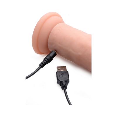 Close-up of a light silicone vibrating dildo with a USB charging cable plugged in for rechargeable use.