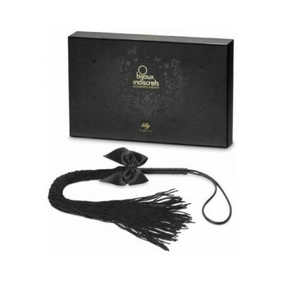 Bijoux Indiscrets Lilly Fringe Whip in black with soft tassels and satin bow, displayed with elegant black packaging box.