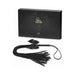 Bijoux Indiscrets Lilly Fringe Whip in black with soft tassels and satin bow, displayed with elegant black packaging box.