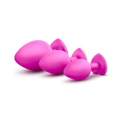 Three pink silicone tapered plugs in small, medium, and large sizes with heart-shaped bases, arranged on white background.
