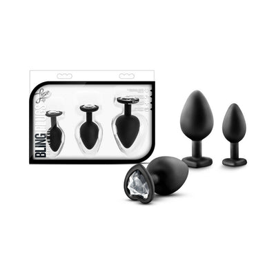 Three black silicone tapered plugs in small, medium, and large sizes with heart-shaped bases and white gem accents, displayed with packaging.