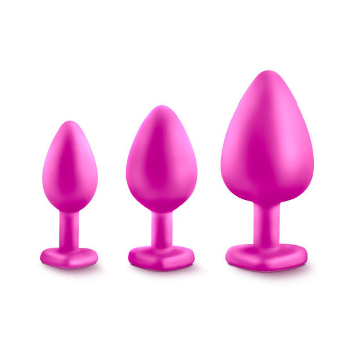 Three pink silicone tapered plugs in small, medium, and large sizes with heart-shaped bases on a white background.