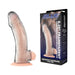 Transparent 6.25-inch flexible penis enhancing sleeve extension with realistic tip and suction base next to product packaging.