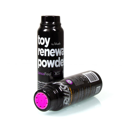 Two black bottles of Blush Toy Renewal Powder with white text and pink twist lids, one standing and one lying down on a white surface.