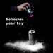 Hand sprinkling white renewal powder onto a black textured toy with text Refreshes your toy on black background.