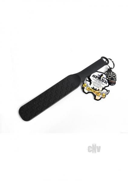 Black silicone paddle with raised skull design, flexible handle, hanging loop, and attached skull keychain.