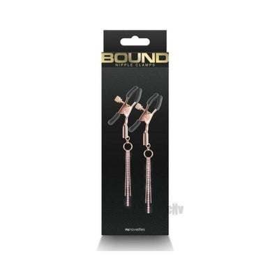 Rose gold adjustable nipple clamps with black silicone tips and decorative chains on black packaging labeled Bound.